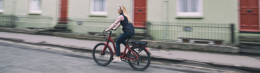Woman riding on a red electric bike by Wisper Bikes